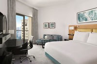 King bed, balcony, pool, amenities.