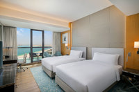 Spacious room with two queen beds and balcony.